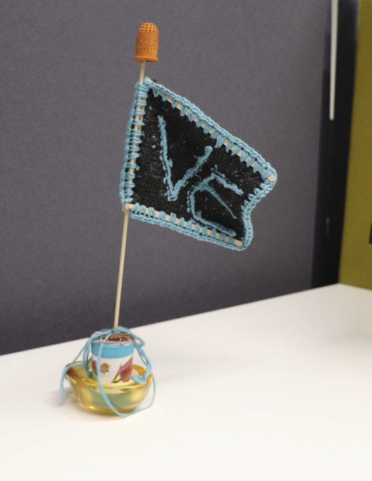 Tilastokeskuksessa ei ole omia työpisteitä.  Paavilainen on kyhännyt työkavereidensa kanssa valtauslipun konttoritarvikkeista ja langasta  virkaten. VE on lyhenne Väestö ja elinolot  -yksiköstä, jossa Paavilainen työskentelee.